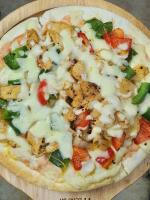 een pizza met kaas en groenten in een houten kom bij Fancy Hostel and Bar in Ha Long