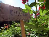 a sign in a garden next to a flower at Apartment in Bramberg am Wildkogel with balcony in Bramberg am Wildkogel