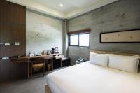 a bedroom with a bed and a desk and a kitchen at The Silence Manor in Ruisui