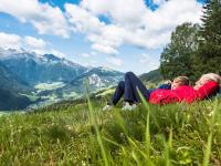 two women laying in the grass on a mountain at Apartment in Bramberg am Wildkogel with balcony in Bramberg am Wildkogel