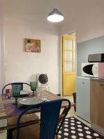a kitchen with a table with chairs and a microwave at À deux pas de la plage in Collioure