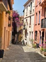 an alley in an old town with purple flowers at À deux pas de la plage in Collioure