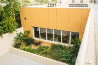 an external view of a yellow building with plants at Twenty Business Flats Béziers in Béziers