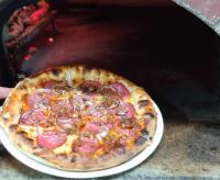 a pizza sitting on a plate in an oven at Spider House Aparthotel in Pamporovo