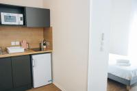 a kitchen with a white refrigerator next to a bed at Twenty Business Flats Béziers in Béziers