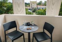 a table with two chairs and wine glasses on a balcony at Twenty Business Flats Béziers in Béziers