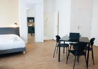 a bedroom with a bed and a table with a laptop at Twenty Business Flats Béziers in Béziers