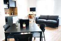 a living room with a table with wine glasses and a couch at Twenty Business Flats Béziers in Béziers