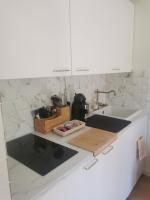 a kitchen with white marble counters and a sink at Appartement cosy dans un chalet d&#39;origine in Bourg-Saint-Maurice