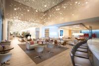 a lobby with a waiting area with tables and chairs at HALL Arts Hotel Dallas, Curio Collection by Hilton in Dallas