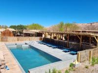 a swimming pool with lounge chairs in the desert at Lodge Altitud in San Pedro de Atacama