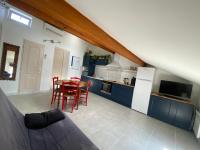 a living room with a kitchen and a table with chairs at Appartement climatisé au pied du Mont Ventoux in Malemort-du-Comtat