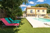 a house with a swimming pool and two lawn chairs at Maison des Charmettes in Nîmes