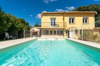 a villa with a swimming pool in front of a house at Maison des Charmettes in Nîmes
