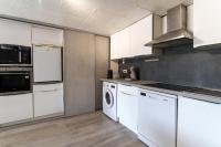 a kitchen with white cabinets and a washer and dryer at Maison des Charmettes in Nîmes