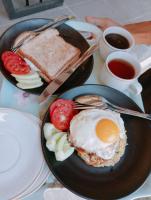 Un plato de desayuno con huevo, tostadas y café. en Tahlia's Villa, en Sorongjukung
