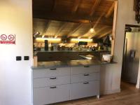 a large kitchen with white cabinets and a refrigerator at Chez Pierrette et Eugène Prix nuitée&#47;10 personne in Le Lautaret