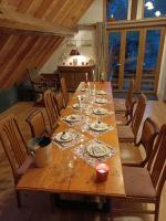 a long wooden table with plates and wine glasses at Chez Pierrette et Eugène Prix nuitée&#47;10 personne in Le Lautaret