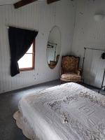 a bedroom with a bed and a mirror and a chair at La Quiétude in Cotignac