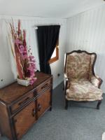 a room with a chair and a dresser with flowers on it at La Quiétude in Cotignac
