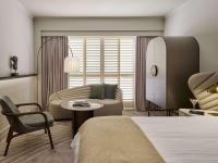 a bedroom with a bed and a couch and a table at The Playford Adelaide - MGallery in Adelaide