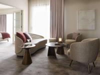 a living room with a couch and two chairs and tables at The Playford Adelaide - MGallery in Adelaide