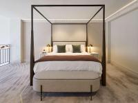 a bedroom with a large bed with a four post canopy at The Playford Adelaide - MGallery in Adelaide