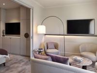 a living room with a couch and chairs and a tv at The Playford Adelaide - MGallery in Adelaide