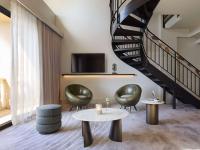 a living room with two chairs and a staircase at The Playford Adelaide - MGallery in Adelaide