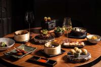 una mesa de madera con copas de vino y comida en art'otel Zagreb, Powered by Radisson Hotels, en Zagreb