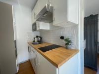 a kitchen with white cabinets and a wooden counter top at Saint Joseph - Vieux Nice, AC, WiFi, 2 pers in Nice
