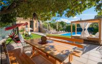 a patio with a wooden table and chairs and a pool at Stunning Home In Vinjani Donji With 5 Bedrooms, Wifi And Outdoor Swimming Pool in Majići