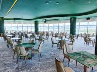 Un comedor con mesas y sillas y ventanas. en YOHO Treasure Island Hotel, en Macau