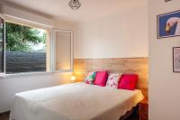 a bedroom with a bed with pink pillows and a window at Les Salons du Bastier 2 in Ginasservis