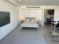 ein weißes Schlafzimmer mit einem Bett und einem Tisch in der Unterkunft oR-Ya Suite in Eilat