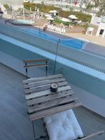 eine Holzbank neben einem Pool in der Unterkunft oR-Ya Suite in Eilat