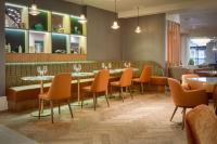 um restaurante com mesas, cadeiras e um bar em DoubleTree by Hilton London Elstree em Borehamwood