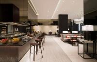 a lobby with a bar with chairs and a couch at Hilton Bengaluru Embassy Manyata Business Park in Bengaluru