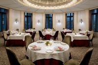 Un comedor con mesas y sillas y una lámpara de araña. en The Tokyo Station Hotel, en Tokio