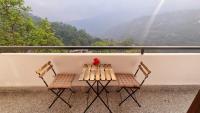 a table and two chairs on a balcony with a view at The Garuda Hotel And Spa in Gangtok
