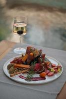 a plate of food on a table with a glass of wine at Surga Alaçatı in Cesme