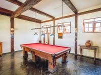 uma mesa de bilhar em uma sala com vigas em VELINN Pousada dos Marinheiros em Ilhabela