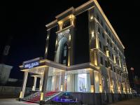 Un gran edificio con luces por la noche. en Royal Plaza, en Qarshi