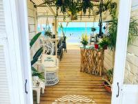 a porch with a table and chairs and the beach at Bungalow de 3 chambres avec piscine partagee et terrasse a Vias a 1 km de la plage in Vias