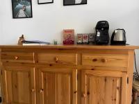 a wooden cabinet with a coffee maker on top of it at Un moment de Détente au cœur de Vals-les-Bains in Vals-les-Bains