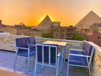 a table and chairs on a balcony with the pyramids at Locanda pyramids view in Cairo