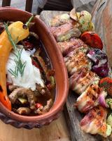 Un tazón de comida sobre una tabla de cortar de madera en Wood Mood Apartman Tiganjica, en Staji°evo