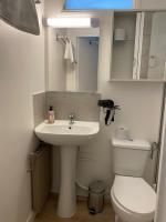 a bathroom with a sink and a toilet and a mirror at Studio de charme in Pantin