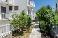 a walkway in front of a building with trees at apartmani stefan in Orebić