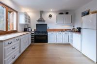 a kitchen with white cabinets and a white refrigerator at L&#39;Orée des Étoiles dans la Vallée de Munster in Stosswihr